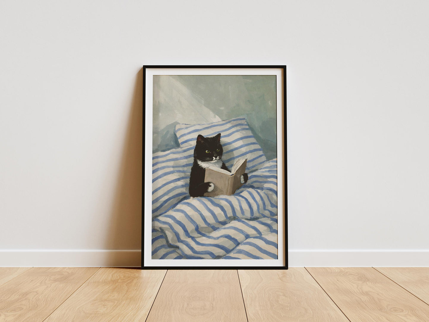 Cozy cat reading art print featuring a black and white tuxedo cat with a book, perfect wall decor for book lovers and reading nooks
