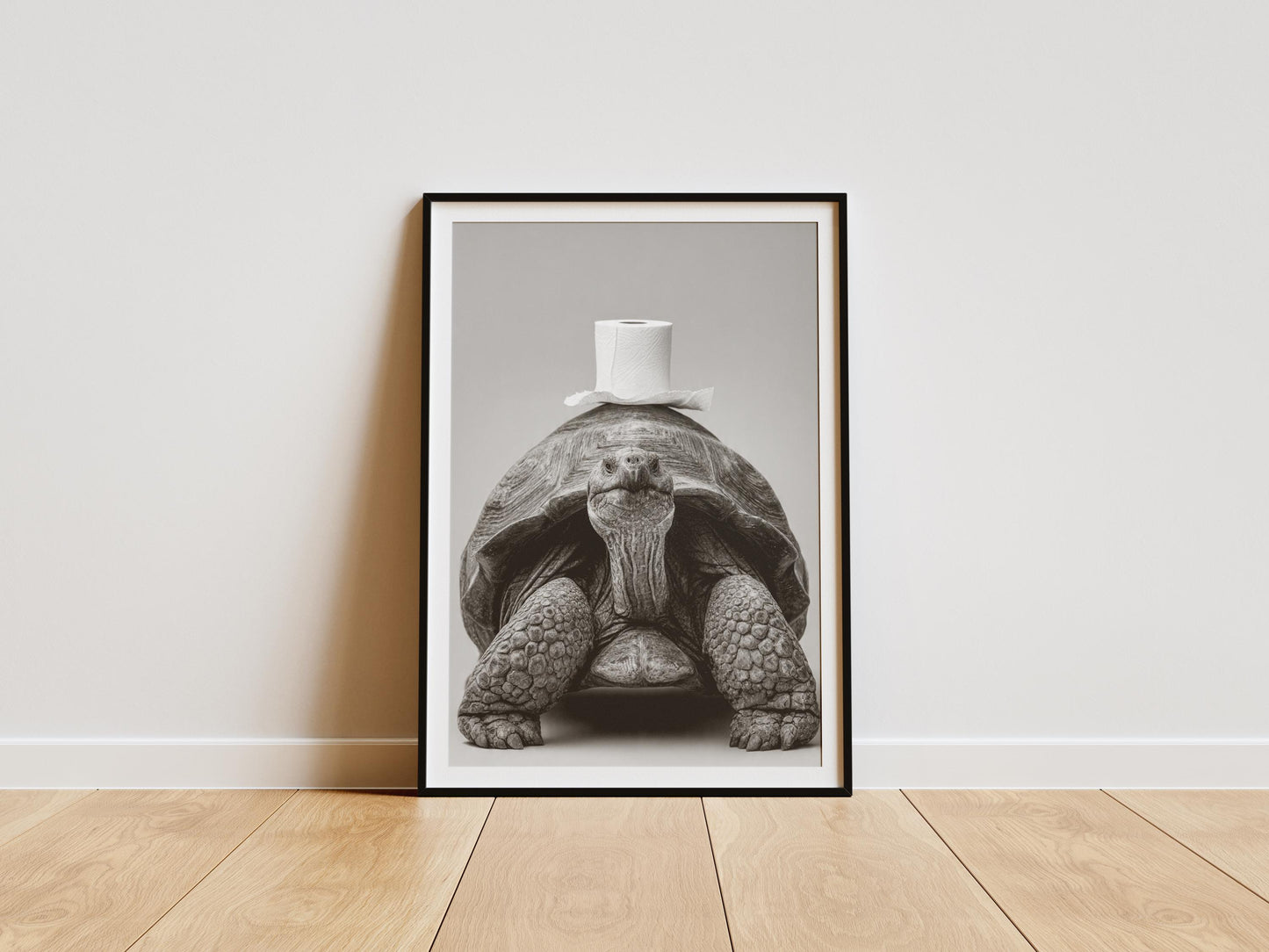 Black and white art print of a giant tortoise facing forward with a roll of toilet paper balanced on its shell, funny bathroom wall art decor