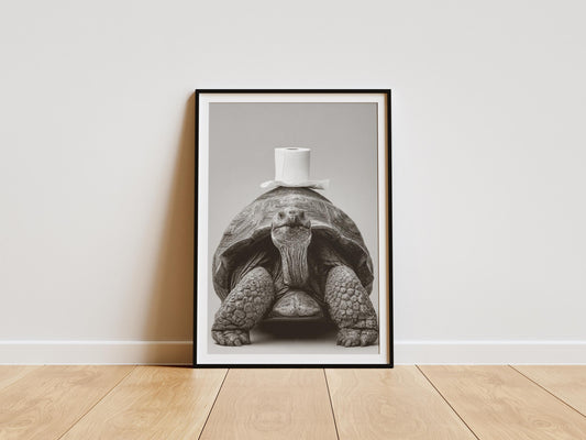 Black and white art print of a giant tortoise facing forward with a roll of toilet paper balanced on its shell, funny bathroom wall art decor