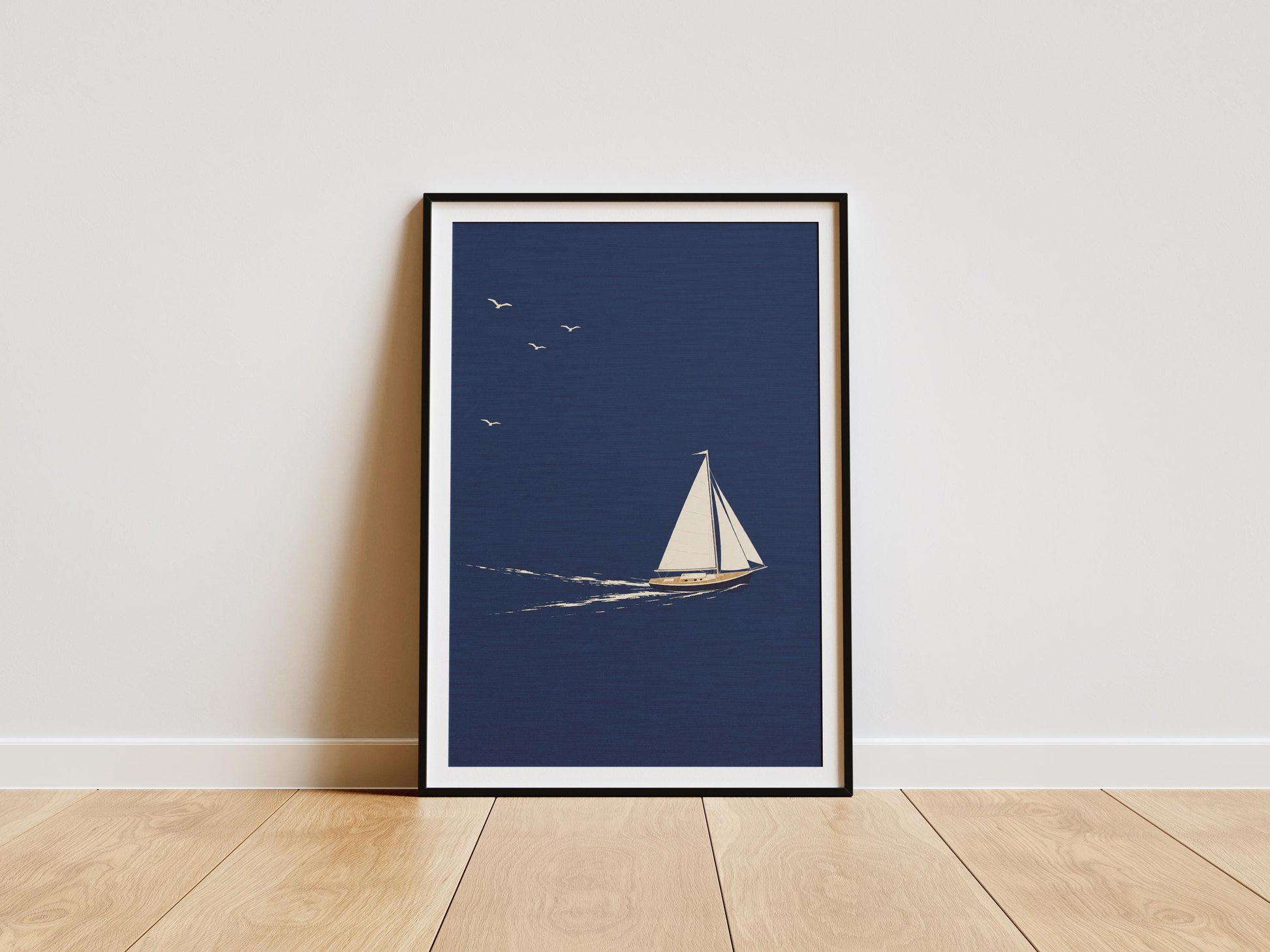 Minimalist sailboat wall art featuring a white yacht sailing across a deep navy blue ocean beneath a clear sky.