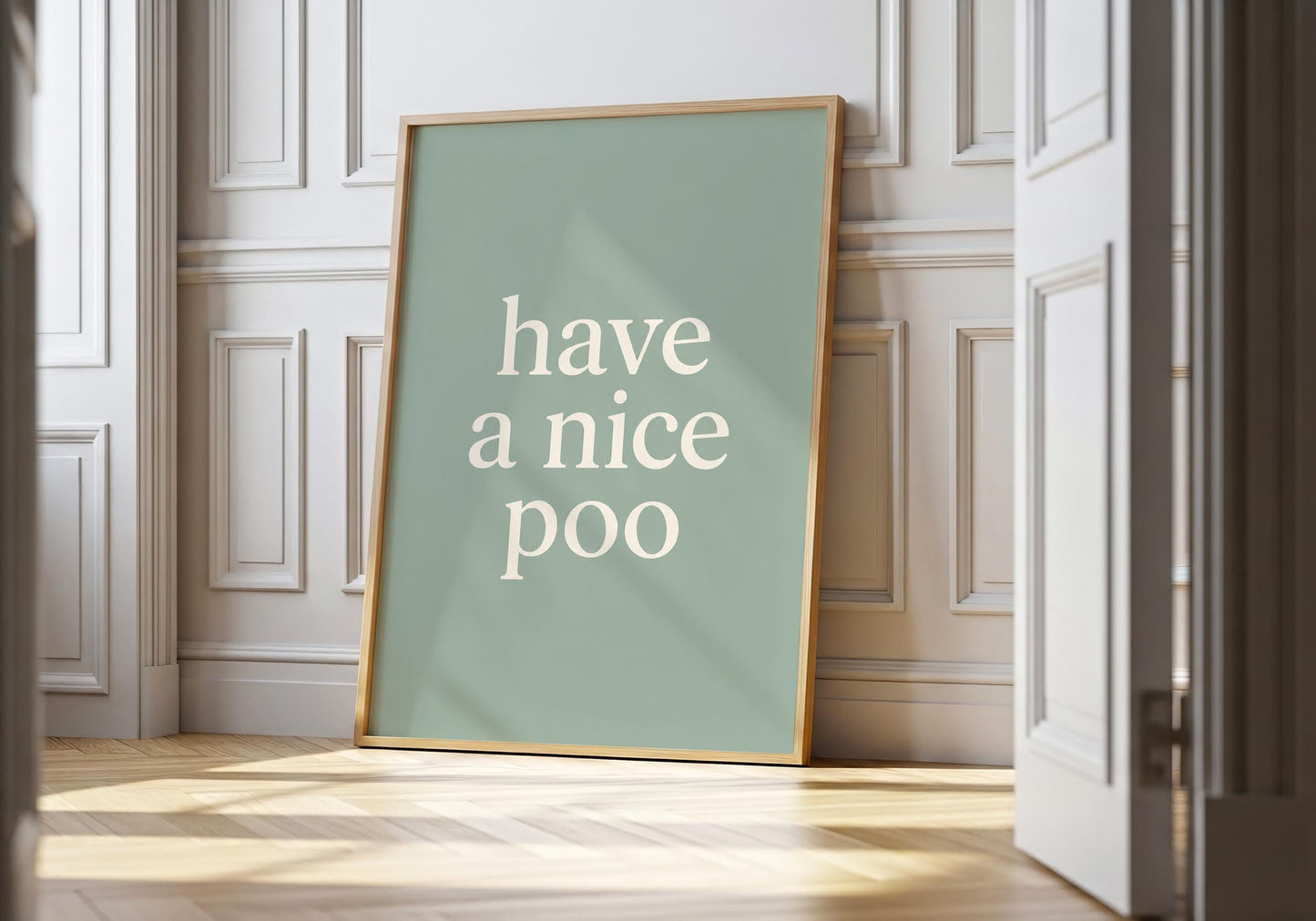 Funny bathroom wall art featuring the phrase "Have a Nice Poo" in minimalist typography on a sage green background.