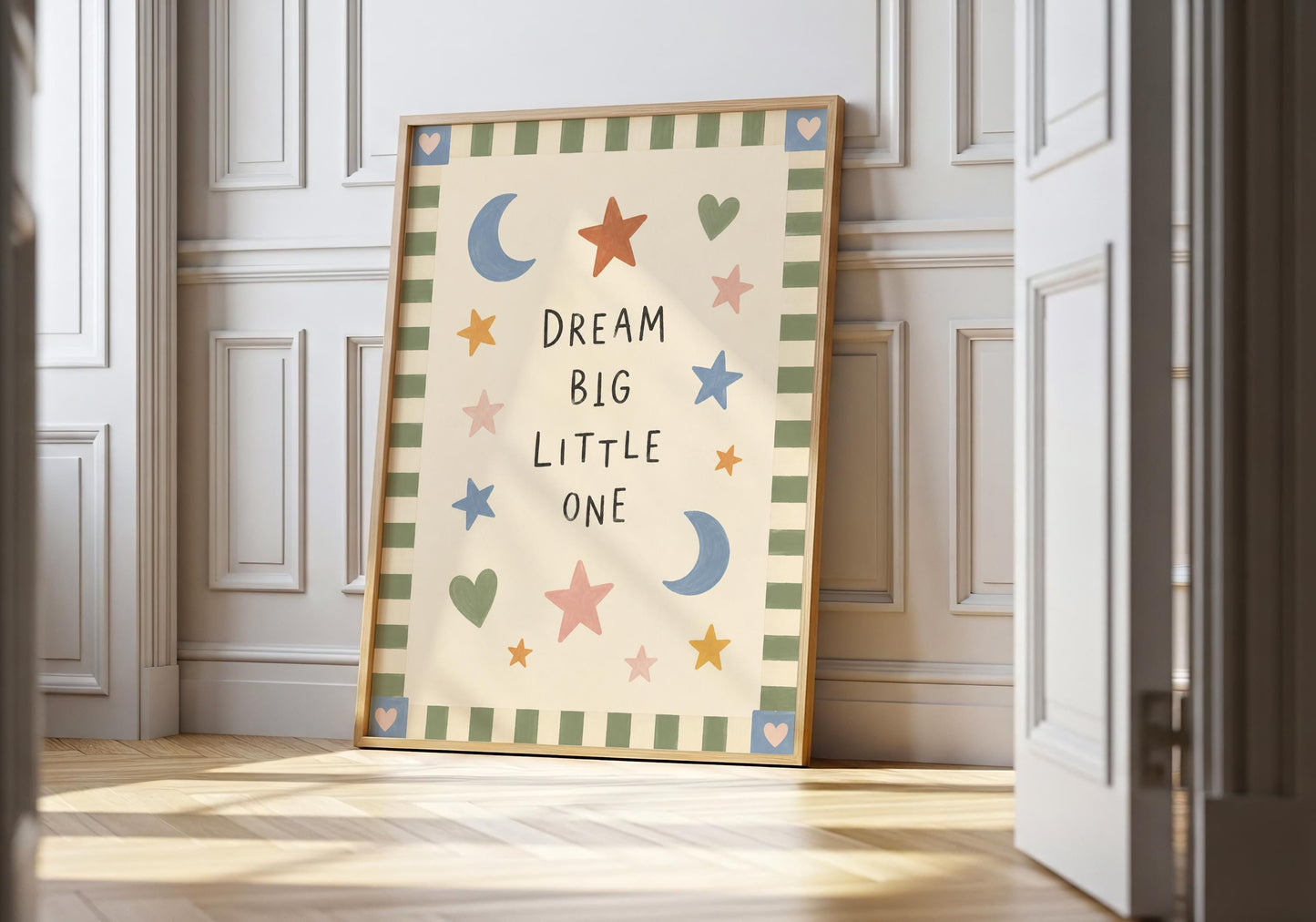 Dream Big Little One nursery print with colourful hand-painted moons, stars and hearts on a warm cream background.