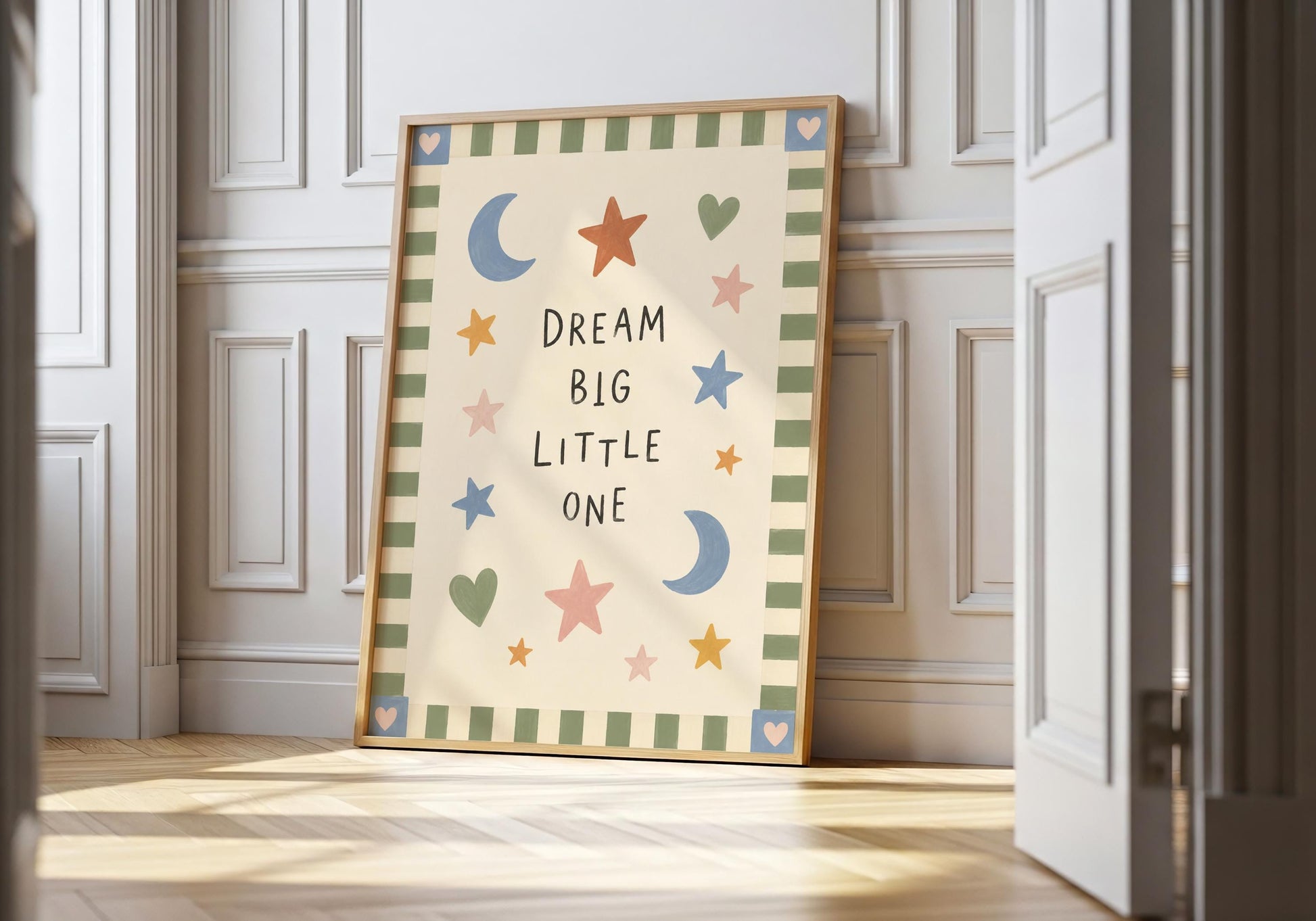 Dream Big Little One nursery print with colourful hand-painted moons, stars and hearts on a warm cream background.