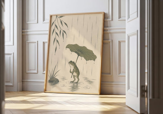 Cute frog wall art featuring a frog holding a lotus leaf umbrella while standing in gentle rainfall.