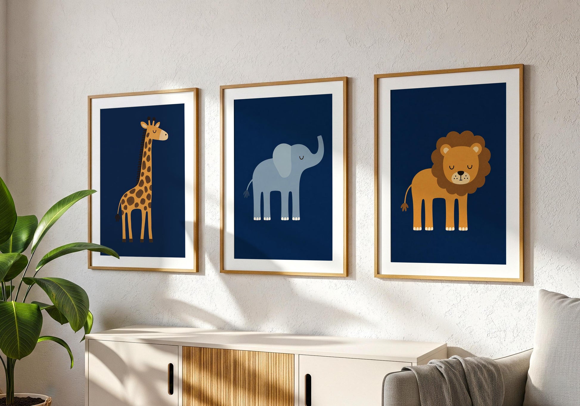 Set of three navy blue safari nursery prints featuring a giraffe, elephant and lion in simple illustrated style.