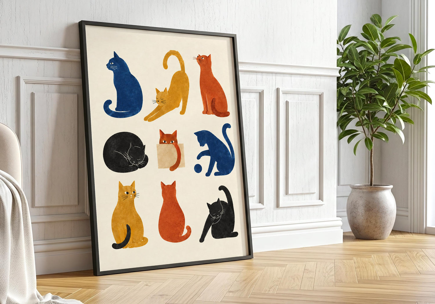 Framed cat wall art displayed against a bright panelled wall, featuring warm orange, mustard, navy and black cat illustrations.