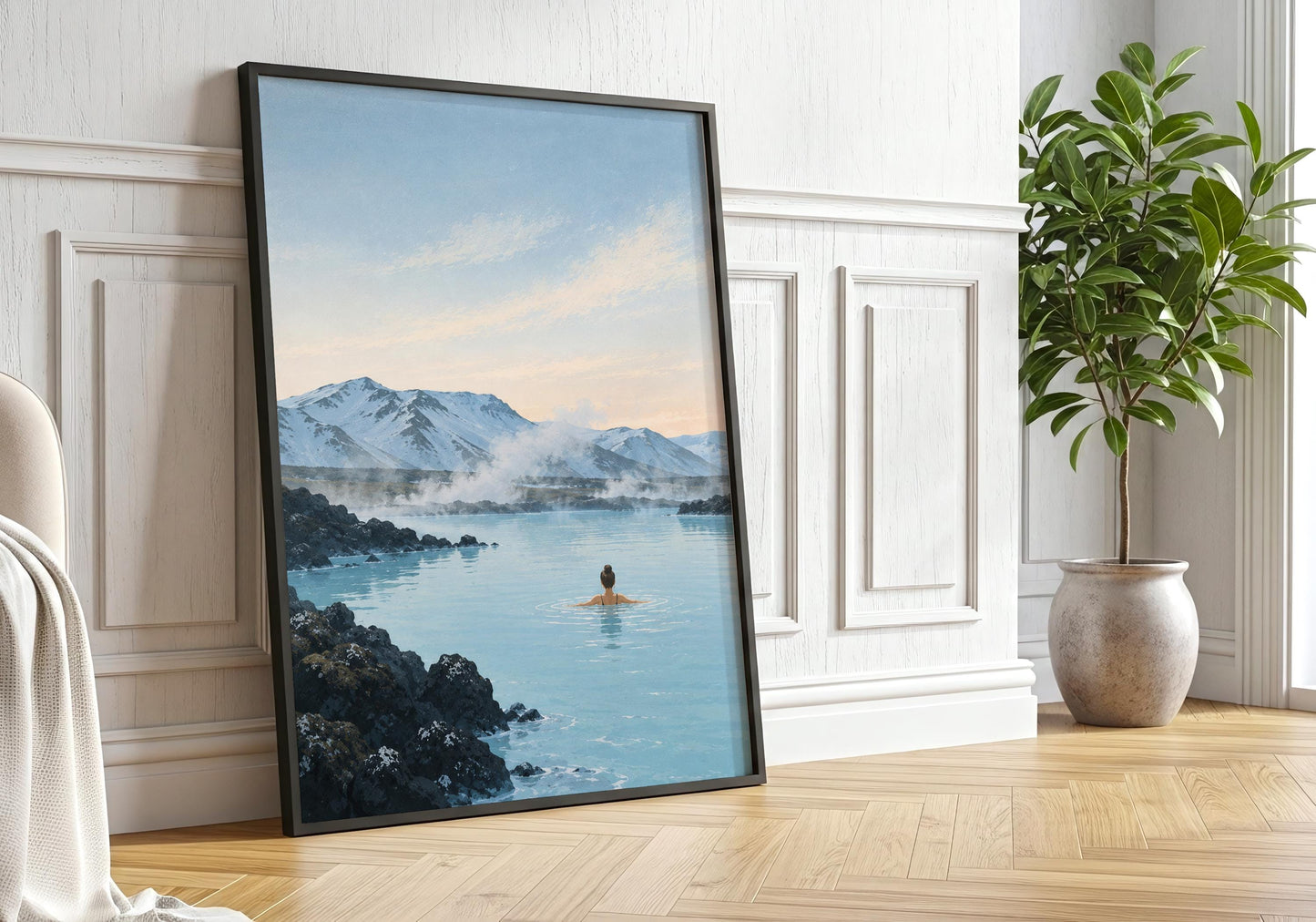 Large framed Iceland landscape print displayed against a white panelled wall in a bright neutral interior with natural wood flooring.