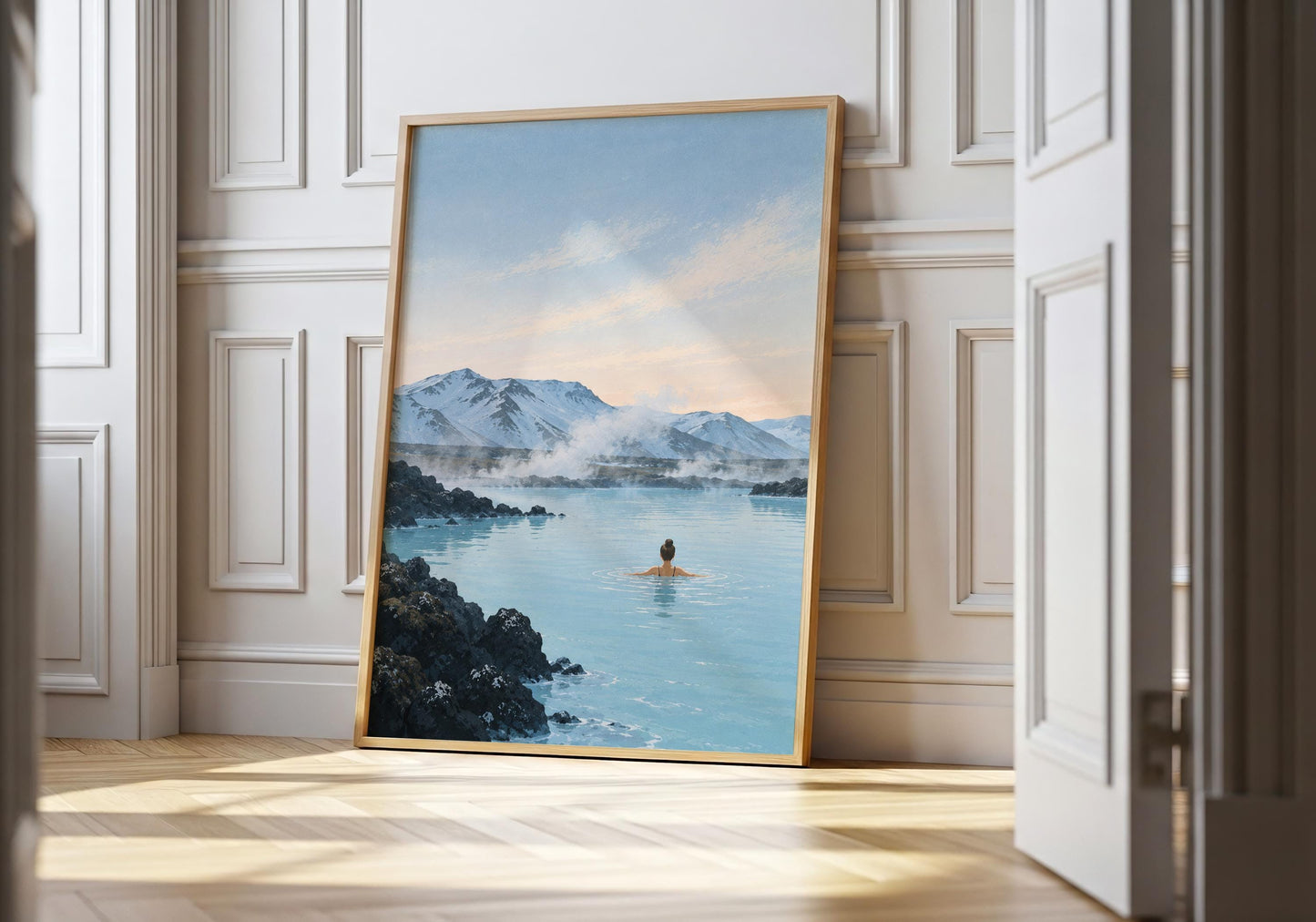 Iceland-inspired wall art showing a lone swimmer in pale blue geothermal water surrounded by black volcanic rocks and snowy mountains.