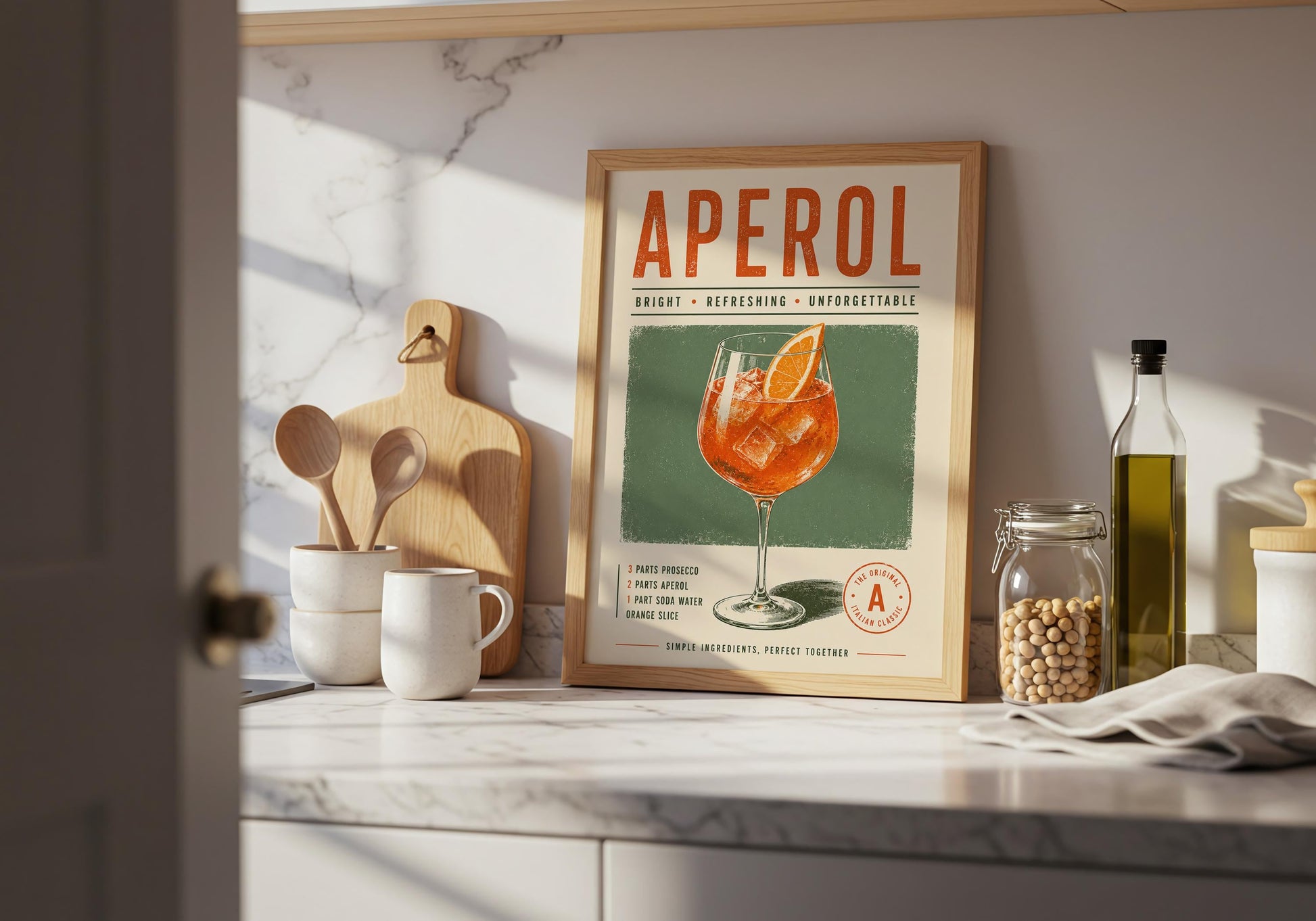 Framed Aperol Spritz art print displayed in a bright interior with warm wooden flooring and decorative wall panelling.