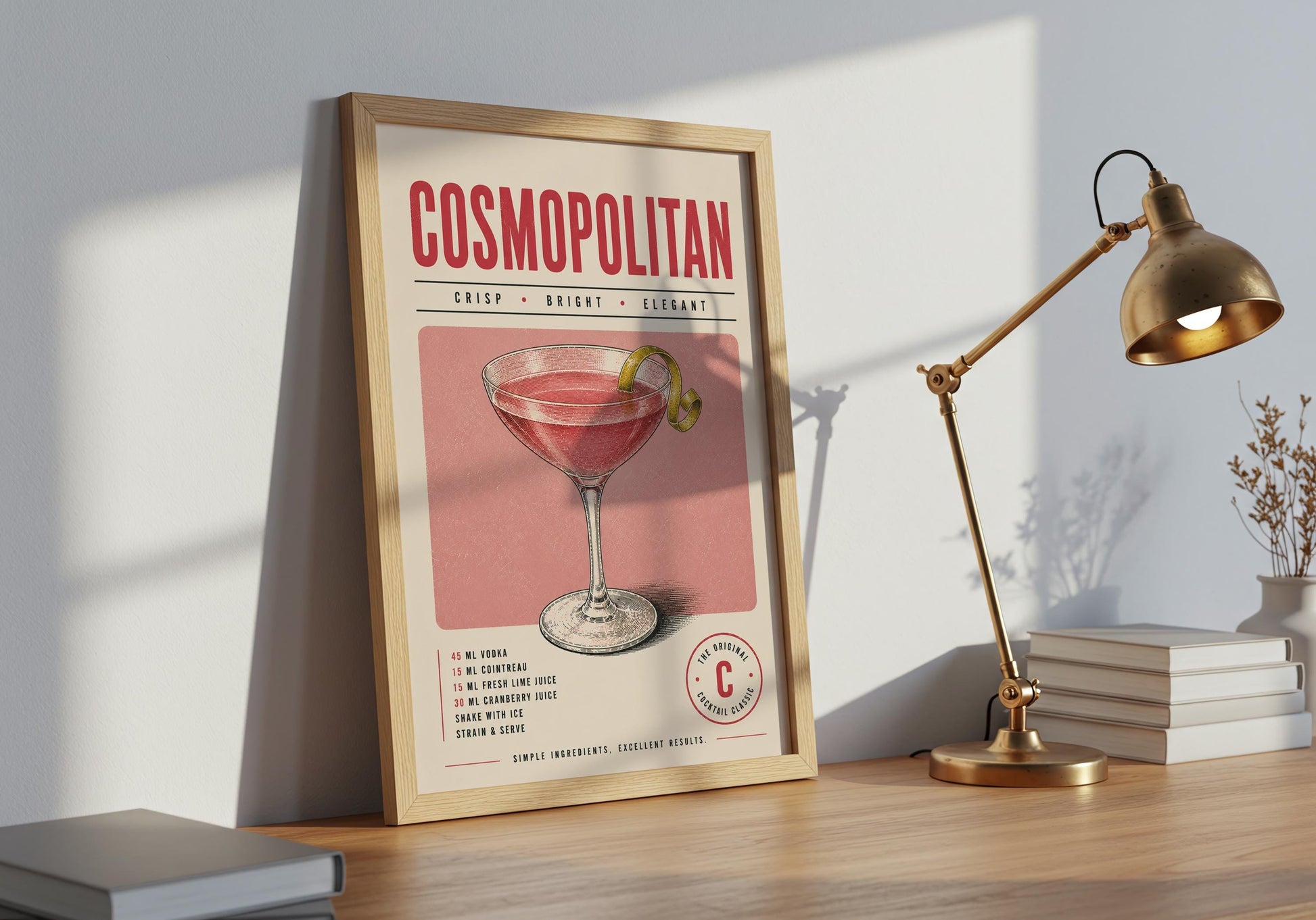 Framed Cosmopolitan cocktail print displayed against decorative white wall panelling in a bright interior.