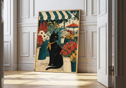Black cat wall art showing a poised black cat surrounded by abundant flowers beneath a striped market awning, leaning in a light natural-wood hero frame against bright white panelling.