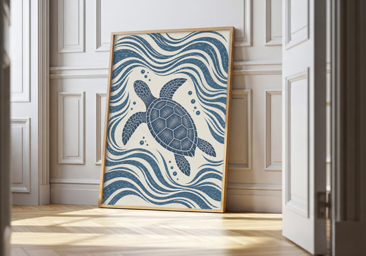Sea turtle print showing a patterned sea turtle gliding through navy waves on a cream background, leaning in a light natural-wood hero frame against white panelling.