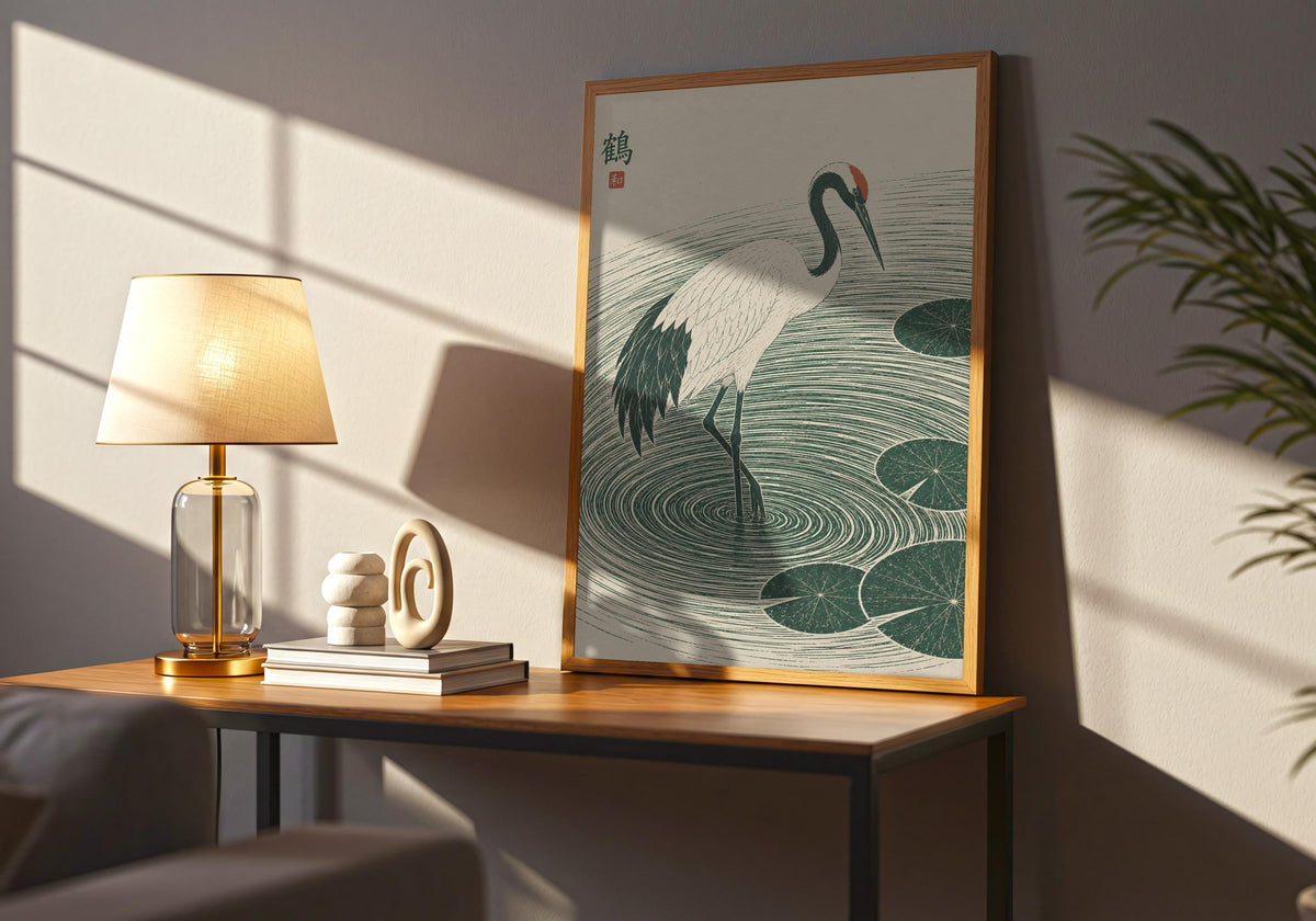 Wide interior view of calm bedroom art with a white crane stepping through deep green ripples and lily pads, standing in a dark wood frame on a side table.