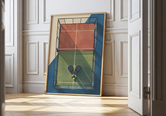 Padel wall art showing an overhead padel court with crossed rackets, geometric colour blocks and long shadows, leaning in a light natural-wood hero frame against white panelling.