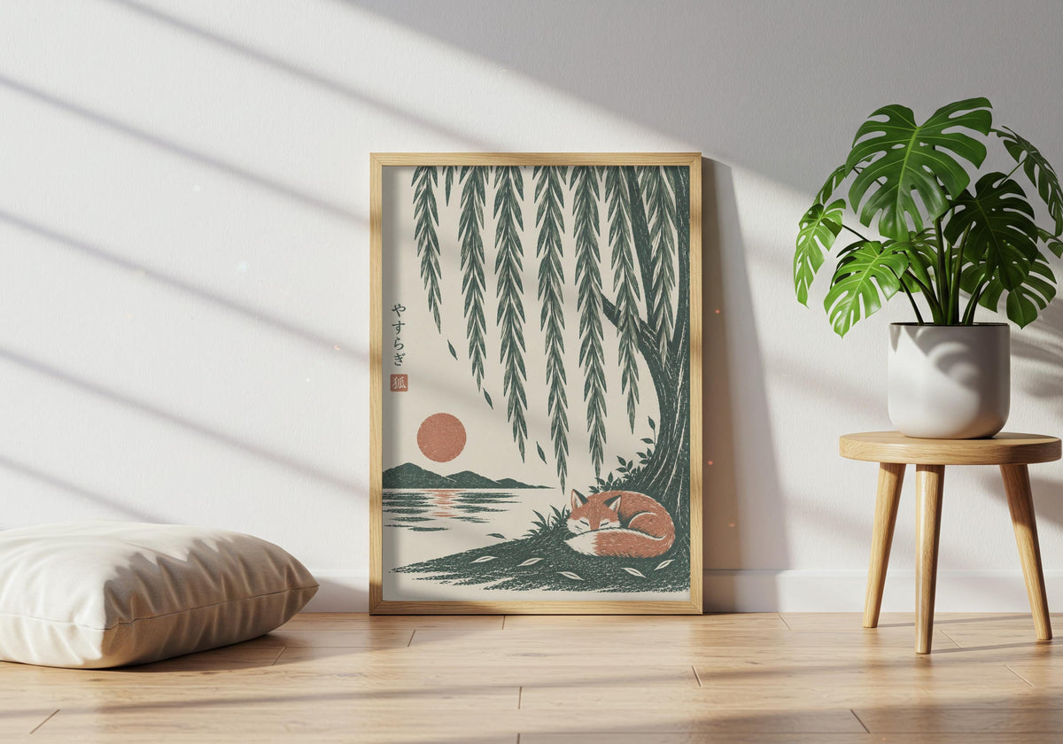 Green wall decor featuring a rust-coloured fox curled asleep beneath cascading willow branches and a low sun, leaning in a light wood frame near a healthy green plant.