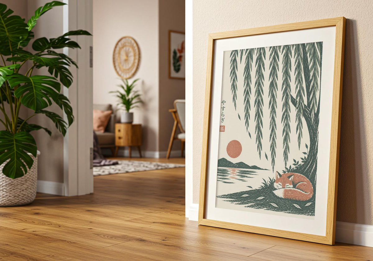 Angled view of calm bedroom art depicting a rust-coloured fox curled asleep beneath cascading willow branches and a low sun, shown at an angle in a light wood frame near a doorway.