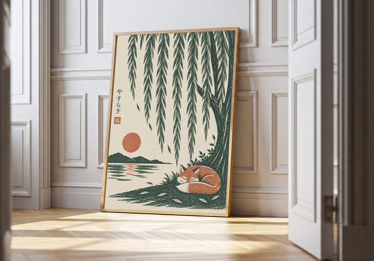 Sleeping fox print showing a rust-coloured fox curled asleep beneath cascading willow branches and a low sun, leaning in a light natural-wood hero frame against white panelling.