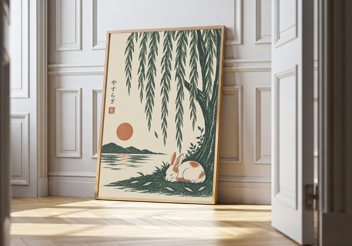 Sleeping bunny art showing a small white rabbit sleeping beside green water beneath long willow leaves, leaning in a light natural-wood hero frame against white panelling.