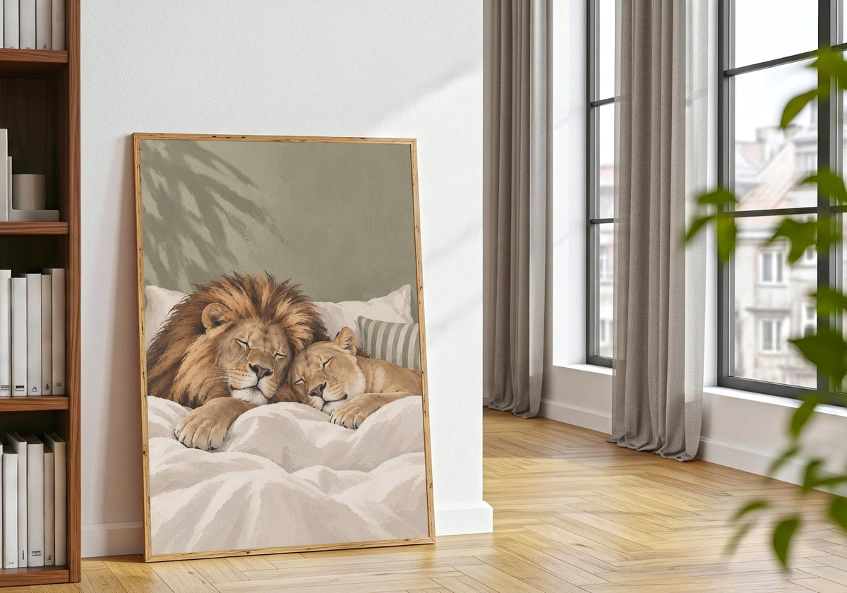Sleeping Lion Print showing a lion and cub enjoying a peaceful bedtime cuddle, displayed in a light natural-wood frame beside houseplants.
