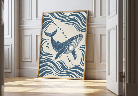 Blue whale print showing a blue whale rising diagonally through flowing navy waves and bubbles, leaning in a light natural-wood hero frame against white panelling.