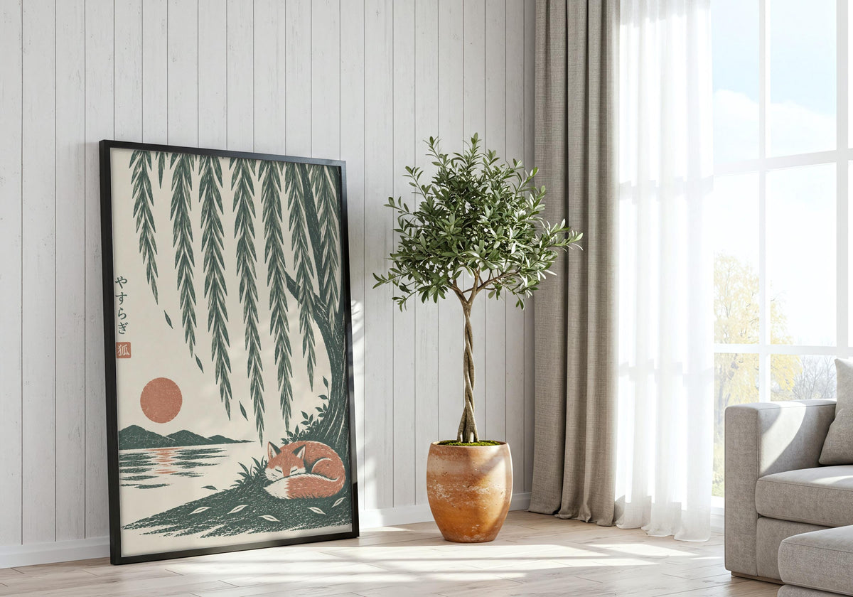 Sleeping Fox Under Willow presented as fox wall art, featuring a rust-coloured fox curled asleep beneath cascading willow branches and a low sun and hung in a black frame beside a bright window.