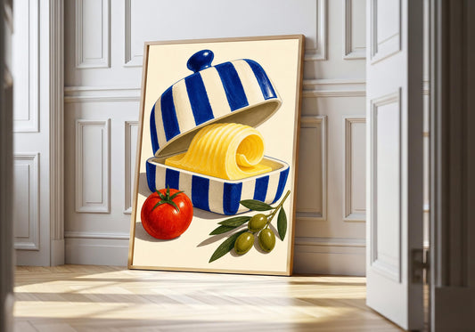 Butter Dish Society butter dish print in a light wood frame, featuring a blue-and-white striped butter dish with a curl of yellow butter, tomato and olives.