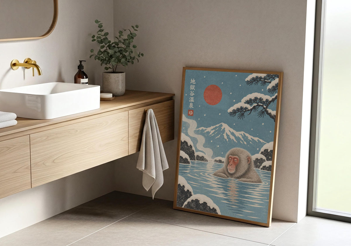 Japanese Monkey Art mockup in a light wood frame by the vanity, with snow monkeys bathing in a blue hot spring beneath a red sun and snowy mountain.
