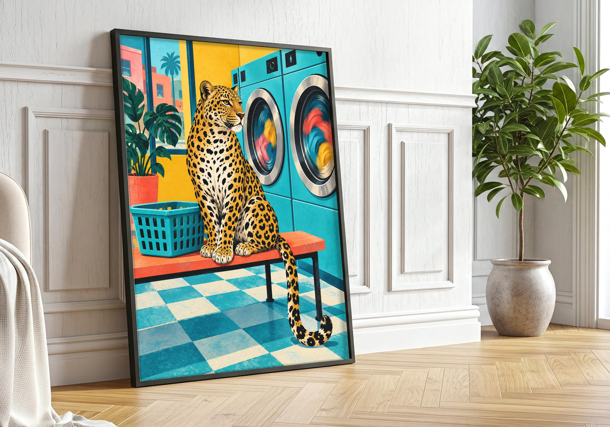 A closer lifestyle view in a black frame with greenery highlights a spotted leopard sitting on a stool in a turquoise retro laundrette beside colourful washing machines and a green laundry basket as colourful leopard.