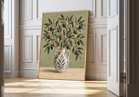 Blue-patterned pottery holds olive foliage in a sage-green print shown against white panelling in a light wood frame.
