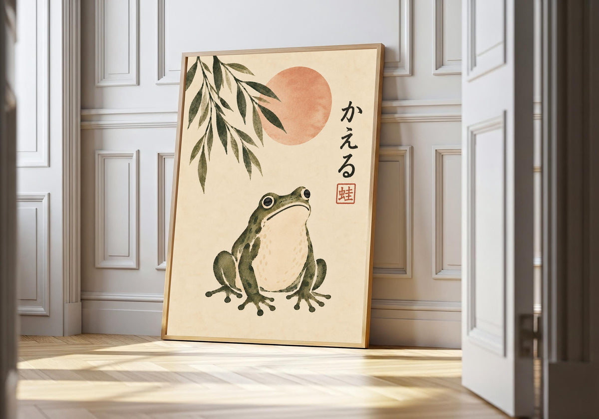 A rounded green frog sits beneath bamboo and a sun in a wood-framed print against white wall panels.