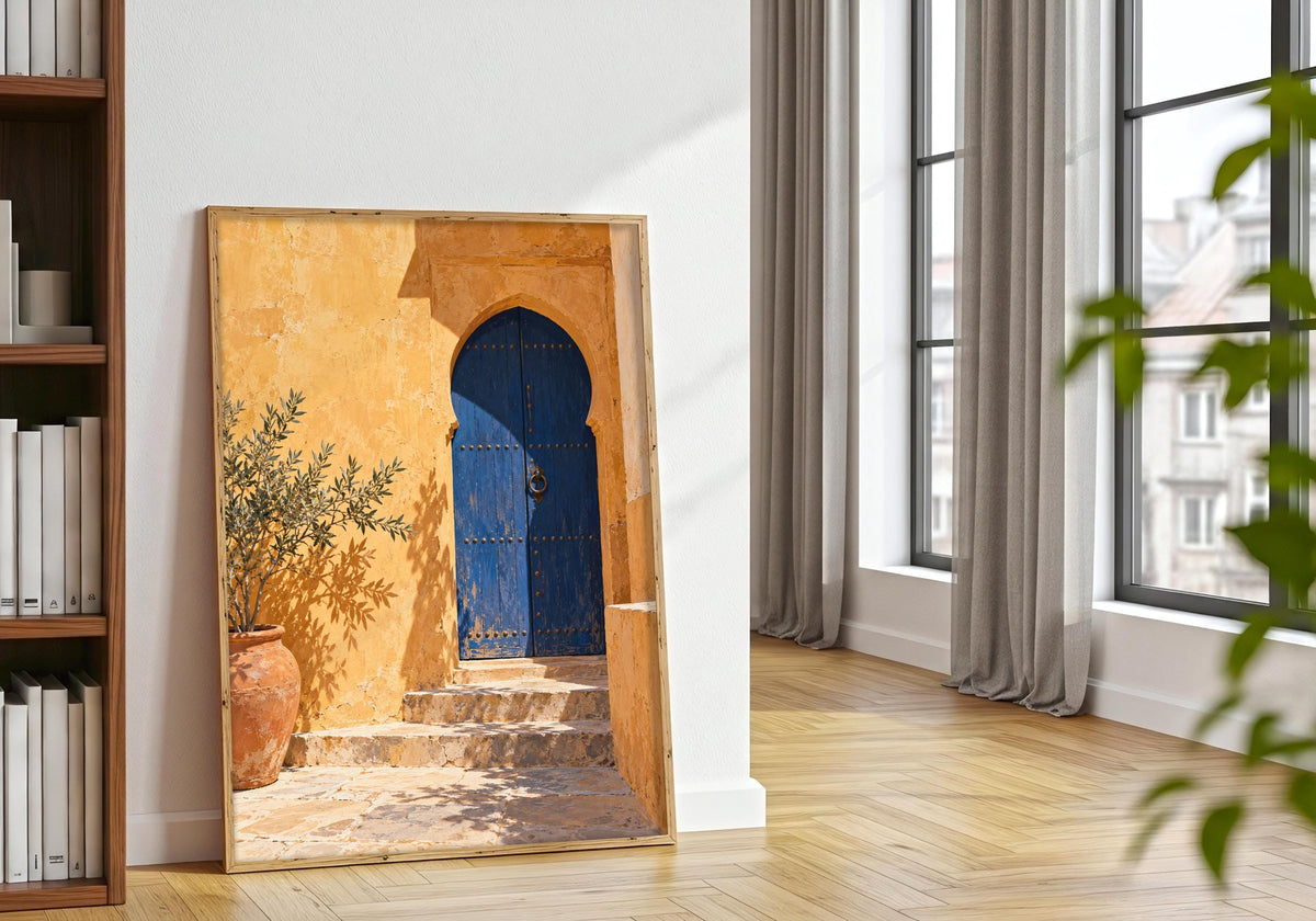 Potted foliage beside the travel-inspired architecture print in natural framing.