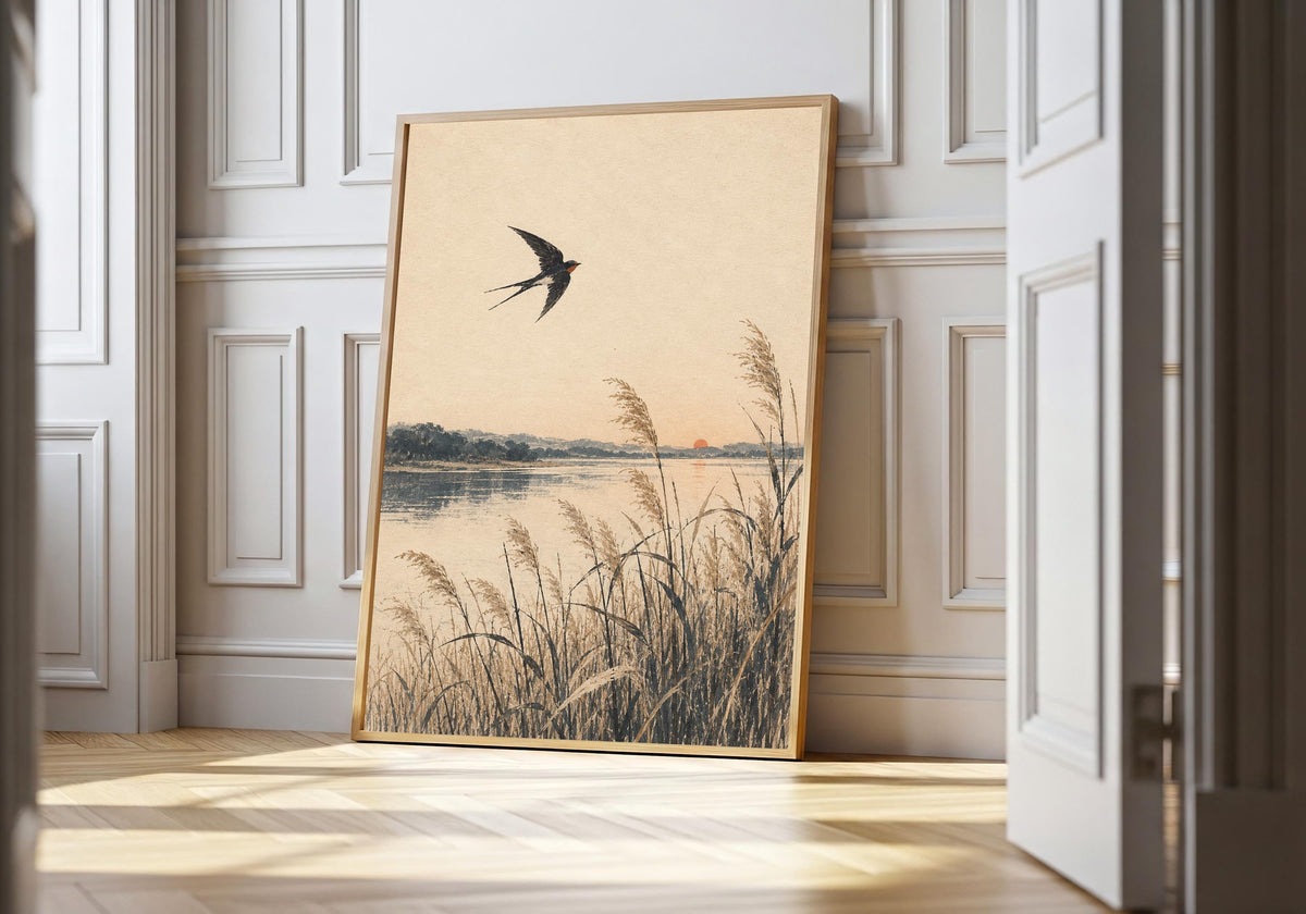 A swallow flies over winter reeds beneath a red sun in the light-wood hero mock-up.