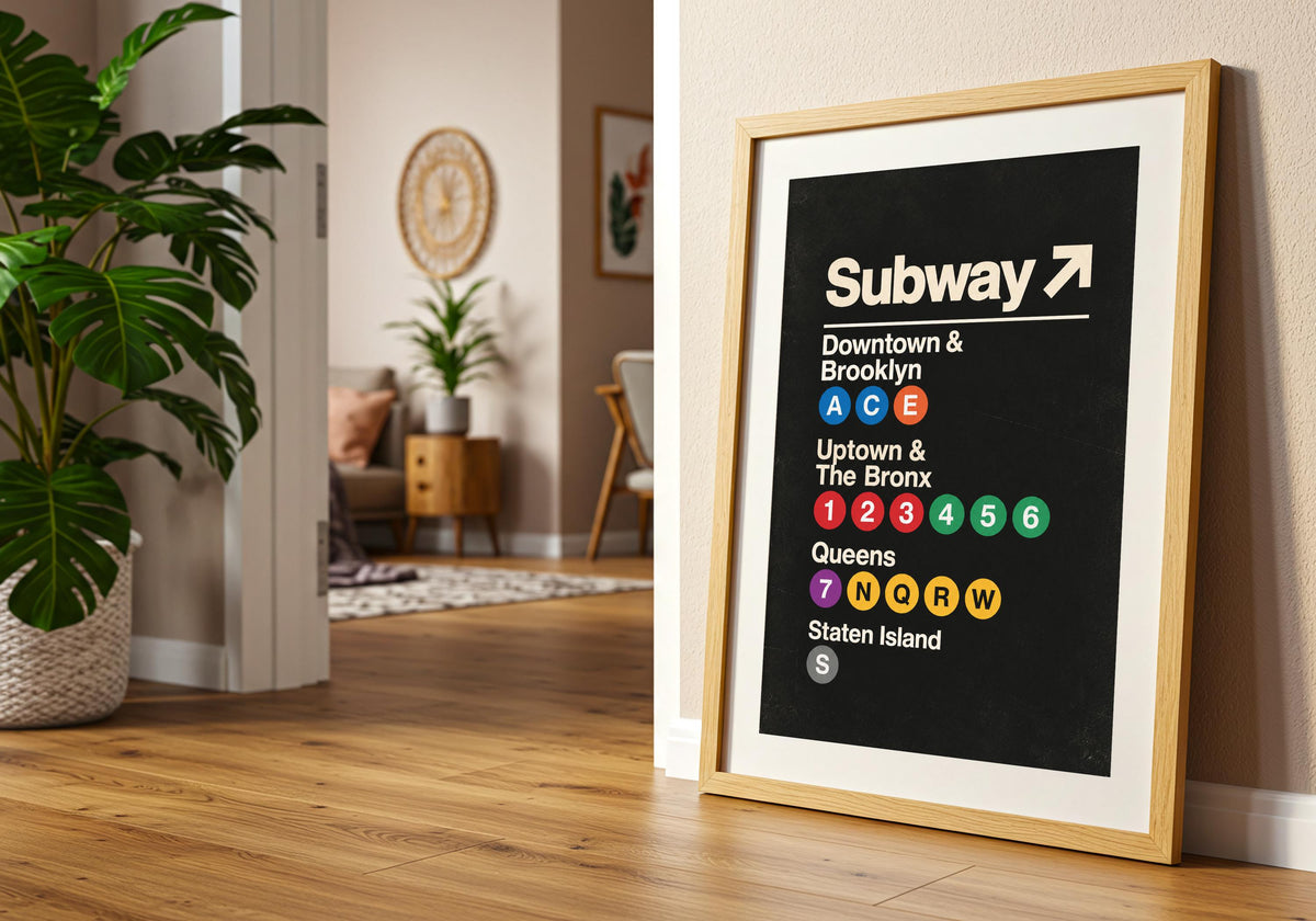 Vintage Subway Wayfinding Poster print in a light wood hero frame, showing bold cream New York subway directions and coloured route circles on black.