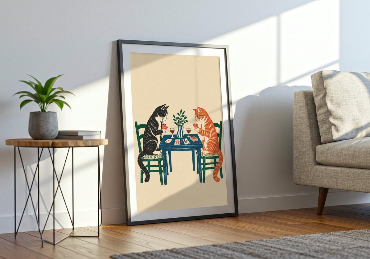 Tuxedo and Tabby Card Game print in a light wood hero frame, showing a tuxedo cat and ginger tabby playing cards over wine at a blue table.