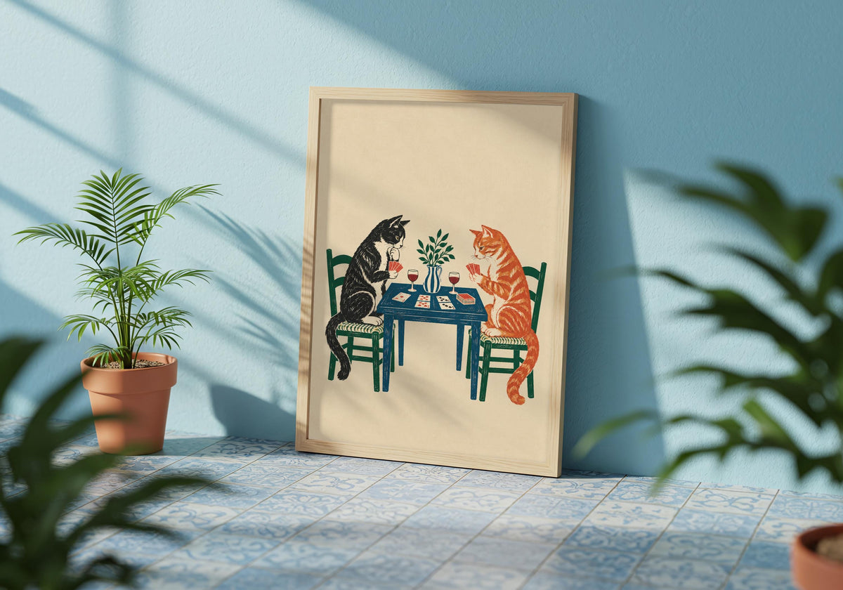 An angled photograph shows how the framed Tuxedo and Tabby Card Game artwork sits within the card game 07 armchair room scene.