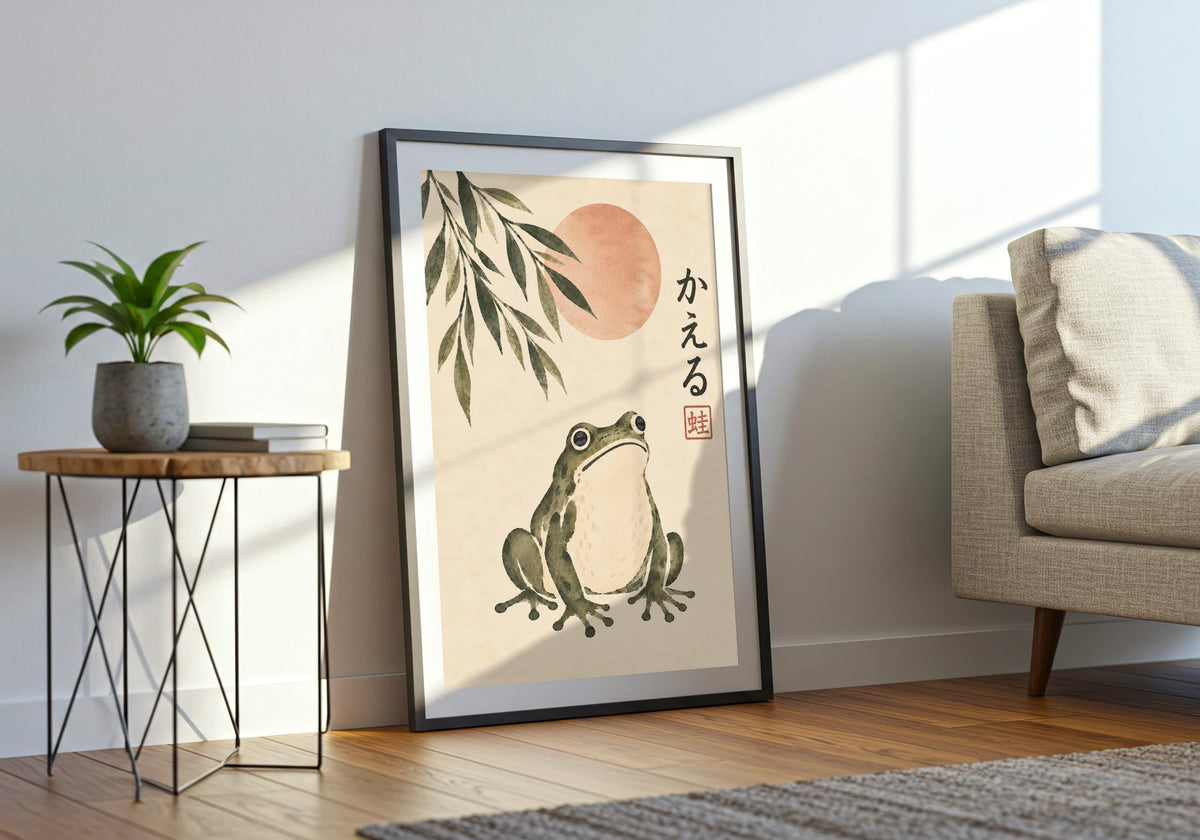 A black frame surrounds the green frog and muted sun in a bright room with an armchair and small plant.