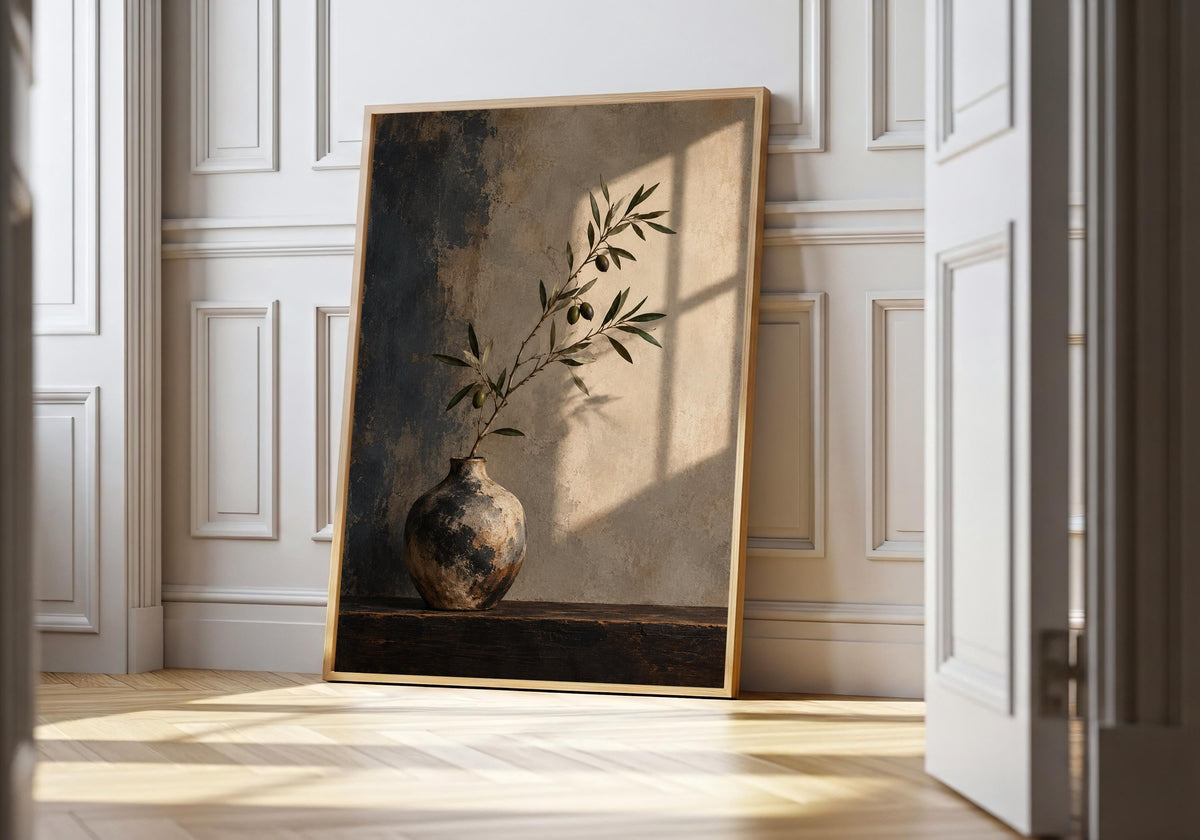 Olive branch in a weathered vase, framed in pale wood in the hero room mock-up.