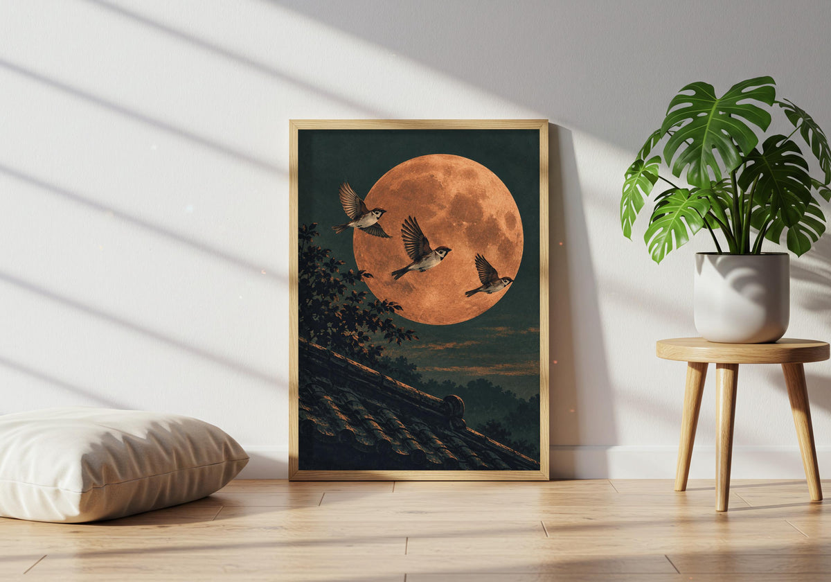 A plant table and floor cushion sit next to the framed view of the moonlit bird scene.