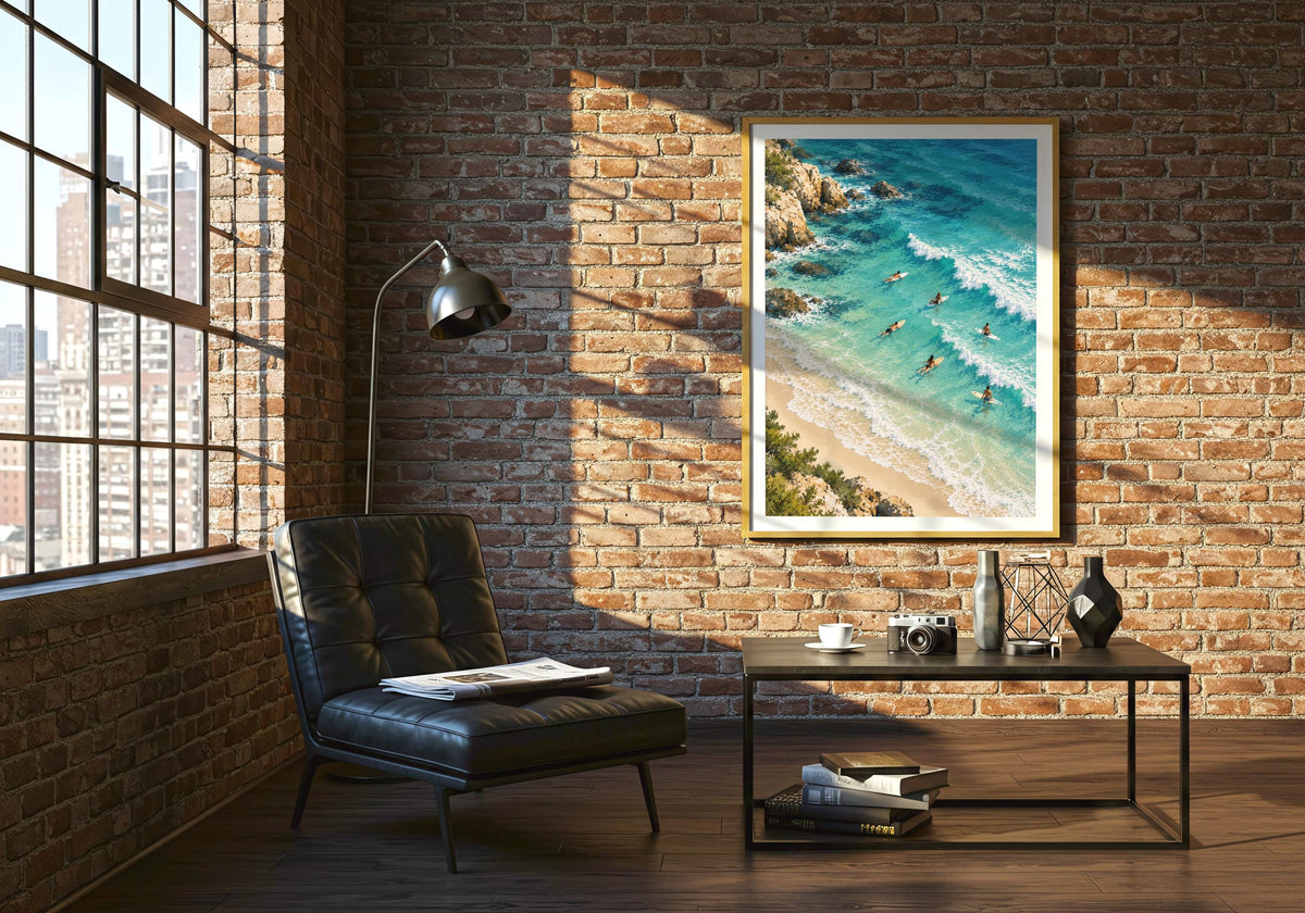 Shown on a brick wall above a black chair, the illustration features rocky edges beside the sea.
